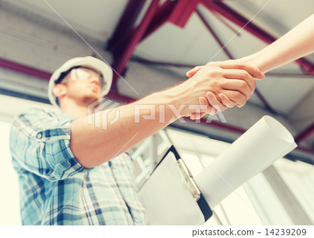 builder with blueprint shaking partner hand builder with blueprint shaking partner hand 14239209
