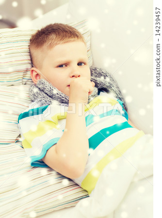 ill boy with scarf lying in bed and coughing ill boy with scarf lying in bed and coughing 14239457