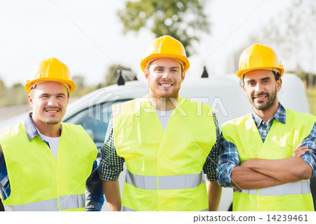 group of smiling builders in hardhats outdoors 14239461