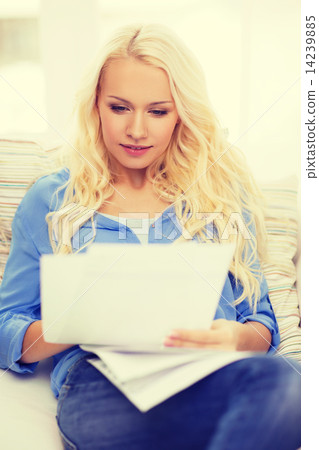 smiling young woman with papers at home smiling young woman with papers at home 14239885