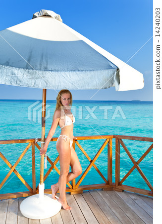 Young woman on a water villa terrace , Maldives Young woman on a water villa terrace , Maldives 14240203