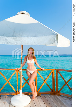 Young woman on a water villa terrace , Maldives Young woman on a water villa terrace , Maldives 14240204