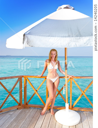Young woman on a water villa terrace , Maldives Young woman on a water villa terrace , Maldives 14240205