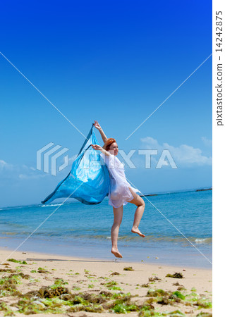 The young attractive woman jumping with a blue scarf in hands.. 14242875