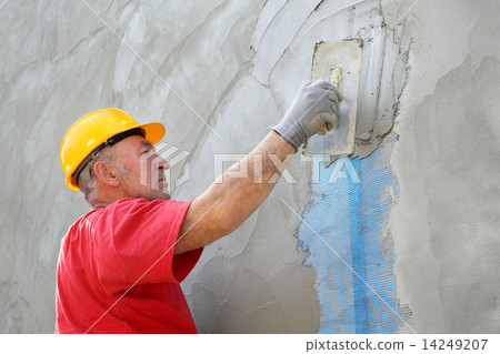Wall insulation, spreading mortar over mesh 14249207