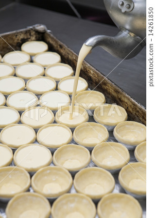 Pot filling egg pudding into puff of egg tart 14261850