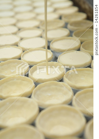 filling egg pudding into puff of egg tart 14261854