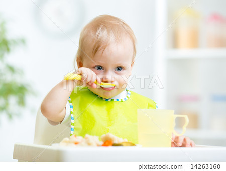 baby child sitting in chair with a spoon baby child sitting in chair with a spoon 14263160