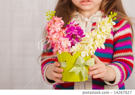 Hands of a little girl with spring flowers in a vase 14267827