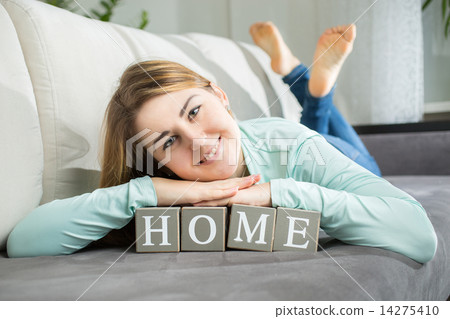smiling woman lying on word "home" spelled by letters on bricks 14275410