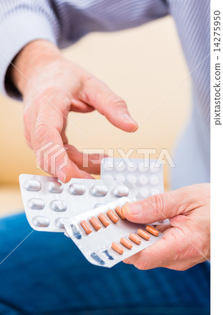Senior medicate with pills at home 14275950