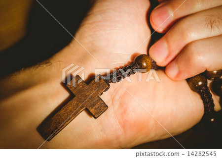 Hand holding wooden rosary beads 14282545