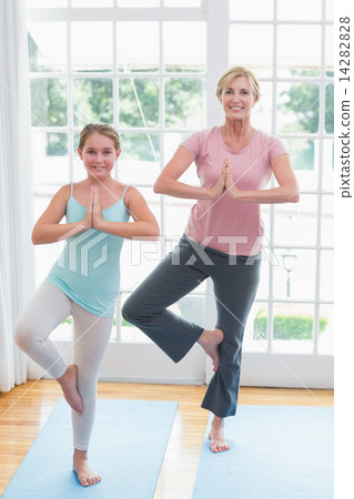 Mother and daughter doing yoga on fitness mat Mother and daughter doing yoga on fitness mat 14282828