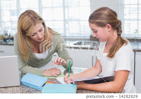 Mother helping daughter doing homework Mother helping daughter doing homework 14282829