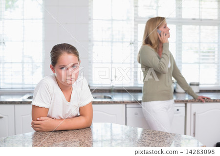 Mother on the phone while daughter sulking Mother on the phone while daughter sulking 14283098