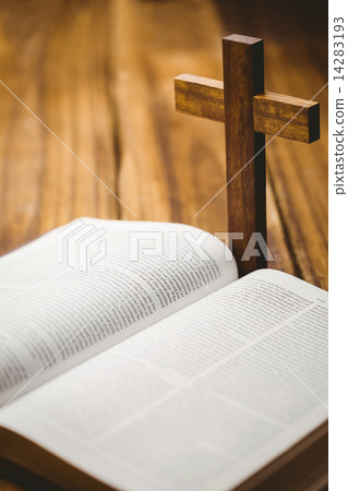 Open bible with crucifix icon behind 14283193