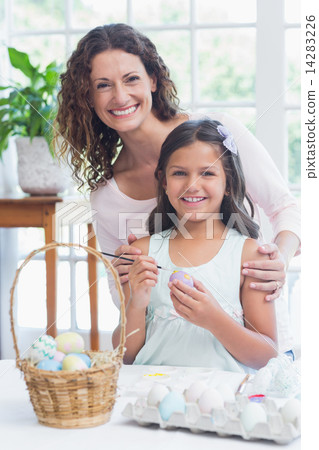 Happy mother and daughter painting easter eggs 14283226