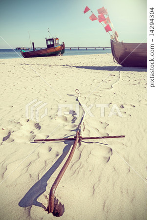Retro style photo of an anchor on the beach. 14294304