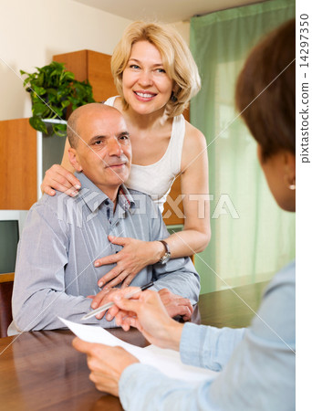 Mature couple with insurance agent Mature couple with insurance agent 14297350