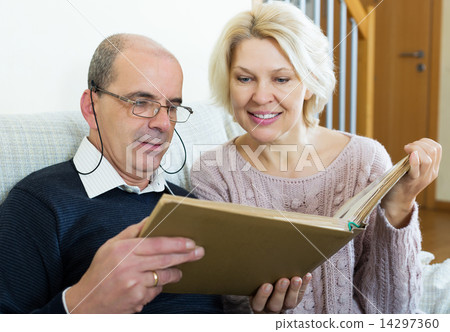 Happy pensioners watching old photoes 14297360