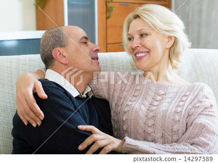 Couple pensioners together on sofa at home Couple pensioners together on sofa at home 14297389