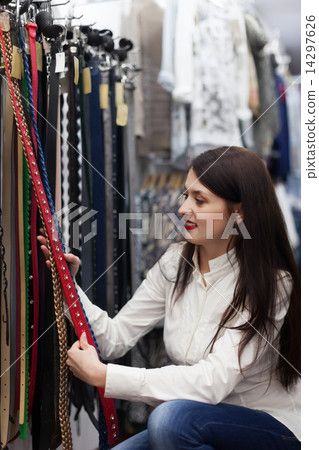woman chooses belt at shop 14297626