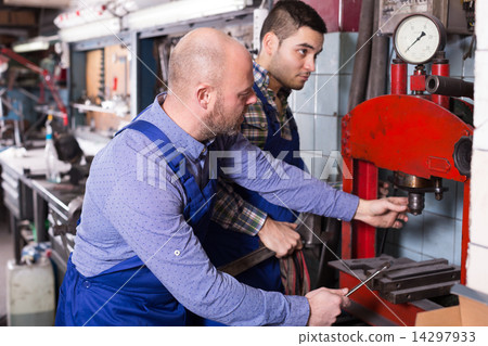Mechanics working at workshop 14297933