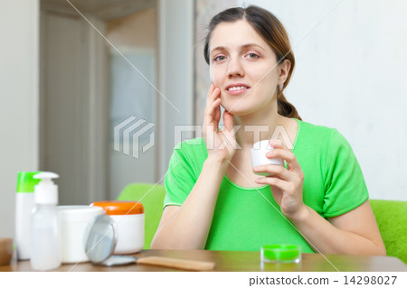 woman in green caring for her face 14298027