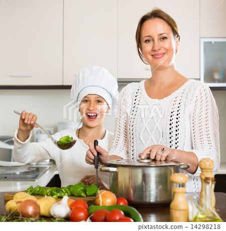 Smiling girl and mom at kitchen 14298218