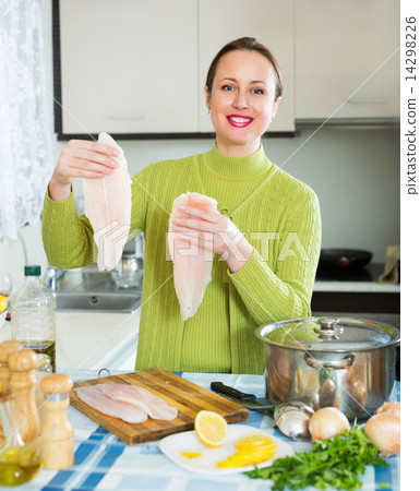 Happy woman cooking fish soup Happy woman cooking fish soup 14298226