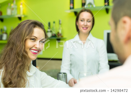 Female barista and two clients in cafe 14298472