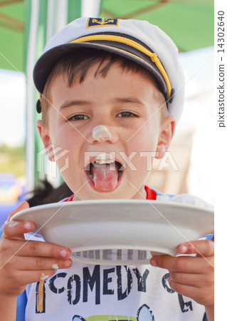 Boy licking a plate 14302640