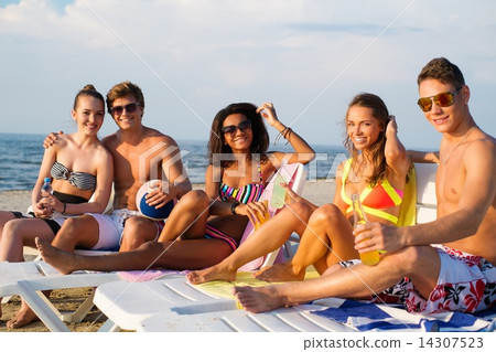 Group of multi ethnic friends with drinks relaxing on a beach 14307523
