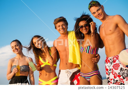 Group of multi ethnic friends with drinks relaxing on a beach 14307525