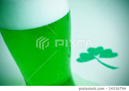 glass with dyed green beer and three-leaved shamrock, for saint 14316794