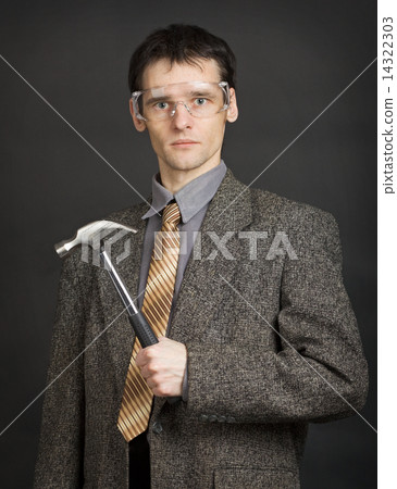 Man in goggles keeps in readiness a hammer 14322303