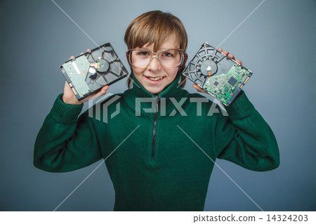 European-looking boy of ten years in glasses holding a hard driv European-looking boy of ten years in glasses holding a hard driv 14324203