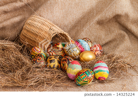 Colorful painted easter egg in wicker basket on hay Colorful painted easter egg in wicker basket on hay 14325224