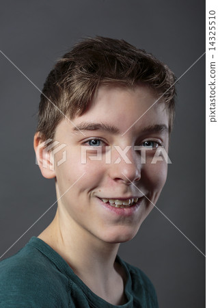portrait of a smiling teenage boy, with gray background for fast 14325510