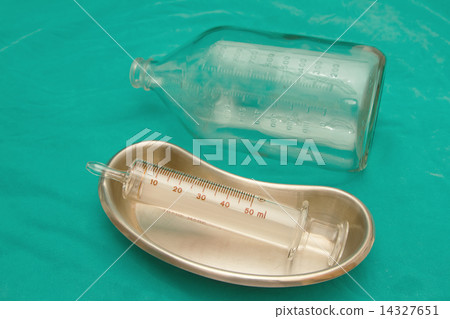 Glass syringe in  sterile basin and glass bottle. for tube feeding diet 14327651