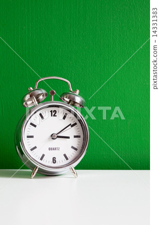 alarm clock near green wall 14331383