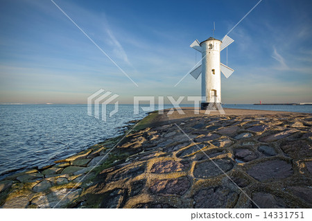 Sunrise on the coast, lighthouse windmill in Swinoujscie, Poland Sunrise on the coast, lighthouse windmill in Swinoujscie, Poland 14331751