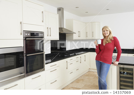 Mature Woman Standing In New Luxury Fitted Kitchen Mature Woman Standing In New Luxury Fitted Kitchen 14337069