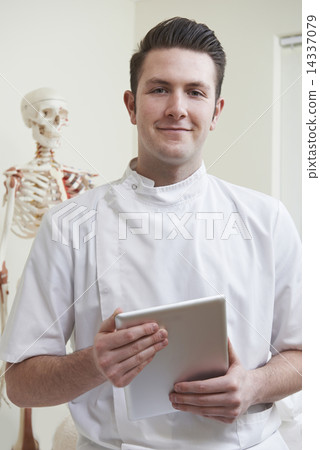 Portrait Of Osteopath In Consulting Room With Digital Tablet 14337079