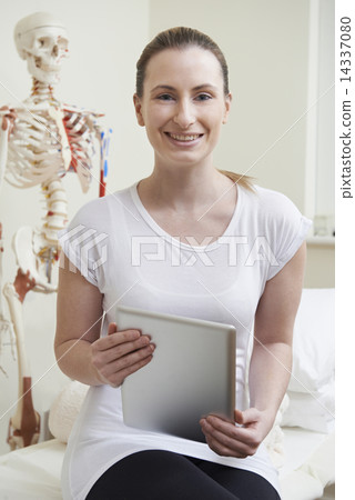 Portrait Of Female Osteopath In Consulting Room With Digital Tab 14337080