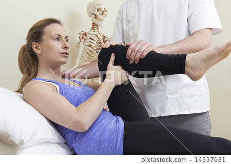 Male Osteopath Treating Female Patient With Hip Problem 14337081
