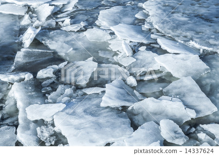 Big ice fragments covered with show on frozen river water 14337624
