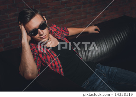 Portrait handsome young hipster man glasses casual clothes unbuttoned shirt sitting relaxing leaning Portrait handsome young hipster man glasses casual clothes unbuttoned shirt sitting relaxing leaning 14338119