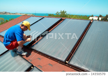 Worker installs solar panels Worker installs solar panels 14350570