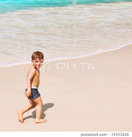 Two year old boy playing on beach Two year old boy playing on beach 14351626